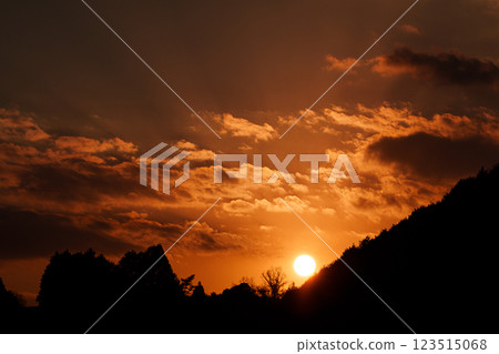 The temperature is rising and it's starting to feel like spring. The sun is setting on the mountainside opposite the Nara Nunome Dam. 123515068
