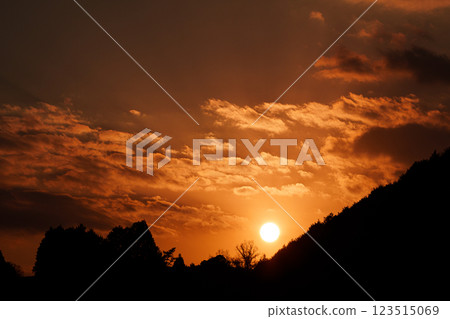 The temperature is rising and it's starting to feel like spring at Nara Nunome Dam. The sun sets over the mountain on the opposite bank. 123515069