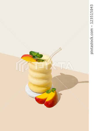 Vegetarian smoothie with mango and banana in a glass on a yellow background with shadow. 123515843