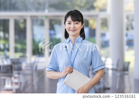 A female facility staff member holding a tablet and smiling while looking at the camera 123516181