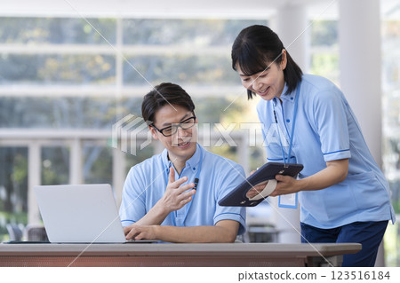 設施工作人員一邊看平板電腦一邊開會 設施工作人員一邊看平板電腦一邊開會 123516184