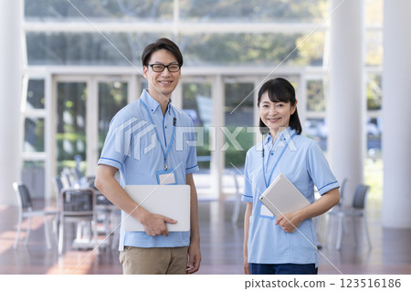 兩名男性和女性設施工作人員對著鏡頭微笑 兩名男性和女性設施工作人員對著鏡頭微笑 123516186