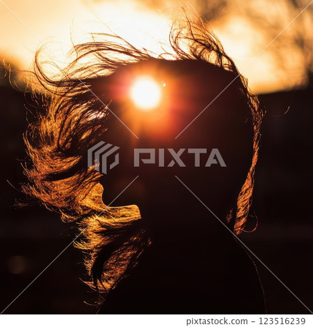 Silhouette of a person with sun setting behind 123516239