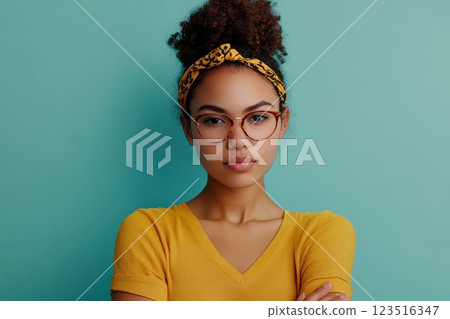 Confident young woman on teal backdrop 123516347