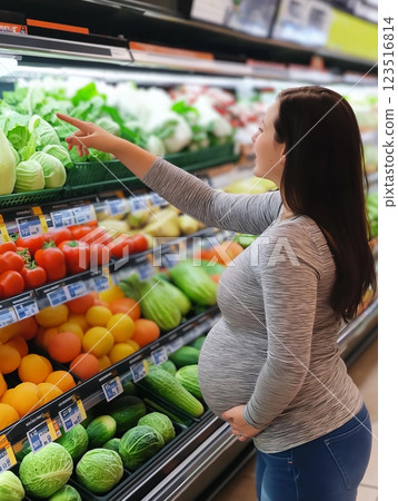 Pregnant woman shopping for healthy vegetables and food at the grocery market store 123516814