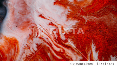 Marble flow. Sparkling ink. Defocused colorful shiny dust polish particles blend abstract background. Orange copper white liquid pigment pour. 123517324