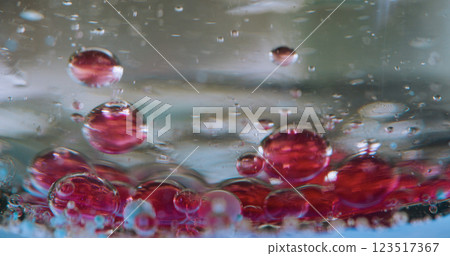Bokeh emulsion bubble. Drops gel. Sedimentation red ingredient on bottom. Mixing air liquid different density. Sink droplet. Chemical process closeup. 123517367