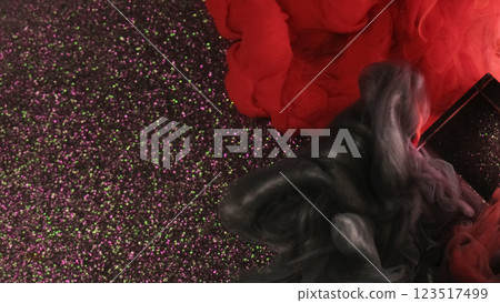 Mixing smoke. Fume paint. Black red fog clouds flow on glittering abstract background. Dissolving contrasting shimmering blurred dye in water with glass cube. Mixing smoke. Fume paint. Black red fog clouds flow on glittering abstract background. Dissolving contrasting shimmering blurred dye in water with glass cube. 123517499