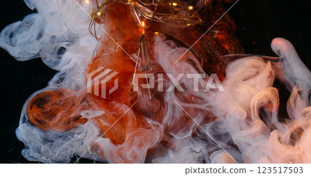 Fume explosion. Paint mix. Glitter orange matte white art fluid streams. Copper cloudy ink spray on black background broken light bulb. 123517503