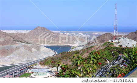 Modern roads wind through mountains, valley, near lake, roads stretching toward ocean, ocean horizon glowing under sunlight, tourists driving along route, tourists admiring breathtaking landscape Modern roads wind through mountains, valley, near lake, roads stretching toward ocean, ocean horizon glowing under sunlight, tourists driving along route, tourists admiring breathtaking landscape 123518161