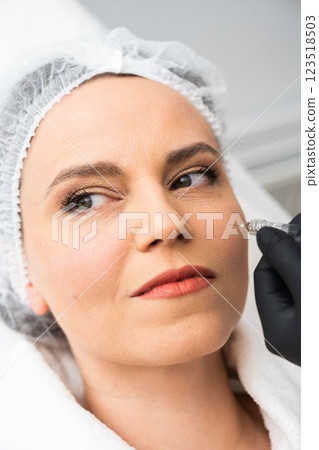 Woman receiving cosmetic treatment in a spa setting with a professional Woman receiving cosmetic treatment in a spa setting with a professional 123518503