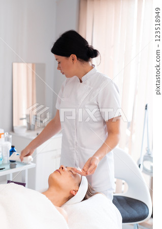 Dermatologist preparing female client for massage 123518949