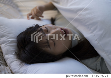 A young woman sleeping in bed 123519271