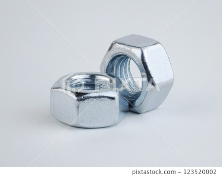Two metallic nuts on a plain background, highlighting their design 123520002