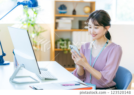 Business woman with a smartphone in the office Business woman with a smartphone in the office 123520148