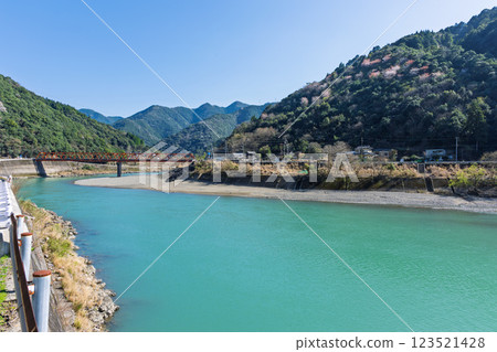 Spring weather: The Kuma River landscape with the natural mountain ranges in the background (Kuma Village, Kuma District) 123521428