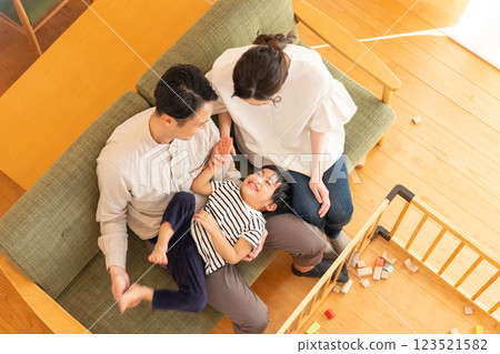 A young couple with a child playing in the living room A young couple with a child playing in the living room 123521582