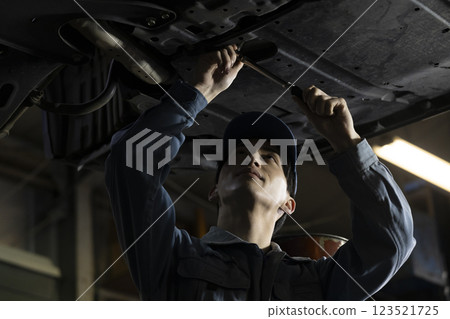 A man maintaining a car A man maintaining a car 123521725