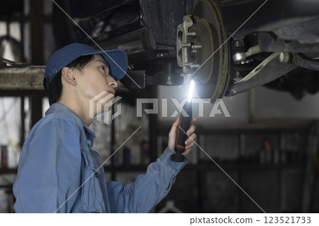 A man maintaining a car A man maintaining a car 123521733