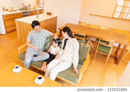 一個在客廳裡放鬆的年輕家庭 123521884