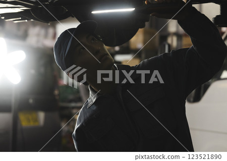 A man maintaining a car A man maintaining a car 123521890