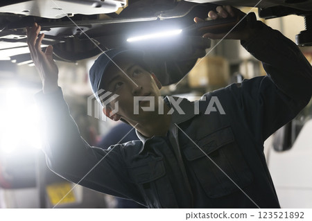 A man maintaining a car A man maintaining a car 123521892