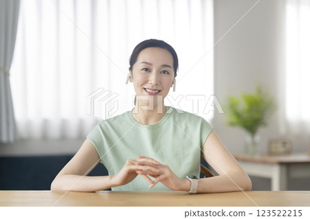 A woman in her 30s wearing earphones talking while looking at the camera 123522215