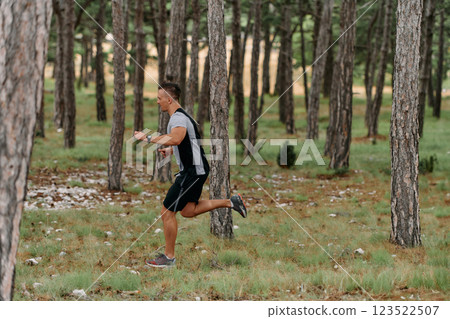Determined Man Conquering Forest Obstacles with Grit and Speed 123522507