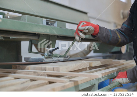 Close Up of Worker Carefully Cutting and Planing Wooden Pieces for Furniture in Wood Industry 123522534