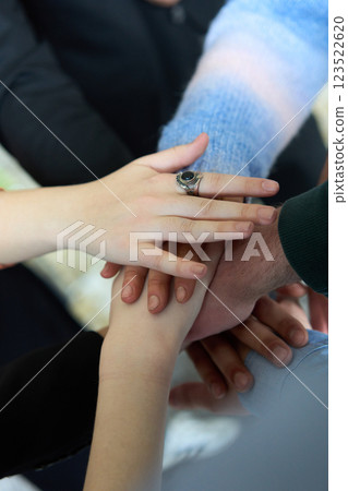 A top view of business people joining hands in a circle, symbolizing unity, collaboration, and shared success in the workplace 123522620