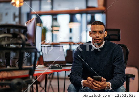 After Hours Reflection: African American Man Using Smartphone in Office. 123522623
