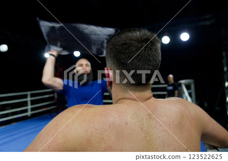 Cornered boxer receives strategic advice from trainer during intense bout. 123522625