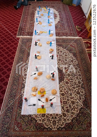 Top view of people serving food at a Mosque a communal meal during Ramadan before breaking the fast on Iftar dinner. Warm festive atmosphere celebrating Ramadan Karim and Eid, the Islamic holy month Top view of people serving food at a Mosque a communal meal during Ramadan before breaking the fast on Iftar dinner. Warm festive atmosphere celebrating Ramadan Karim and Eid, the Islamic holy month 123522676