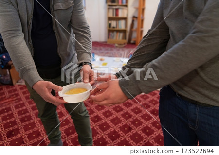 Top view of people serving food at a Mosque a communal meal during Ramadan before breaking the fast on Iftar dinner. Warm festive atmosphere celebrating Ramadan Karim and Eid, the Islamic holy month 123522694