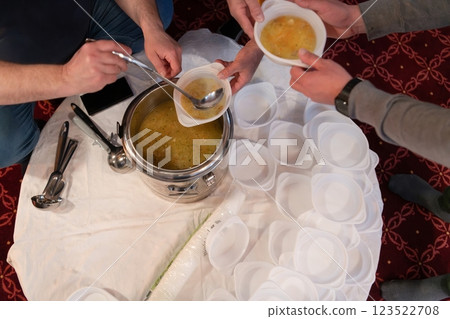 Top view of people serving food at a Mosque a communal meal during Ramadan before breaking the fast on Iftar dinner. Warm festive atmosphere celebrating Ramadan Karim and Eid, the Islamic holy month 123522708