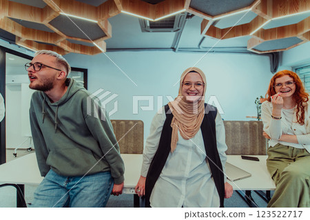 A group of young business professionals stands together, taking a well-deserved break from their busy workday, showcasing camaraderie, teamwork, and a moment of relaxation in their dynamic workplace 123522717