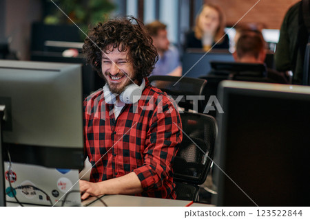 Focused Programmer With Afro Hairstyle in Plaid Shirt Working on Computer in Office Environment Focused Programmer With Afro Hairstyle in Plaid Shirt Working on Computer in Office Environment 123522844