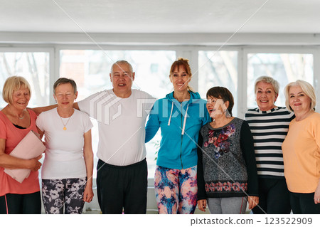 A group of seniors and one man happily pose with their yoga instructor after a successful training session. 123522909