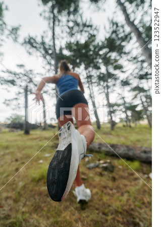 Adventurous Woman Overcoming Forest Obstacles with Determination and Agility. 123522947