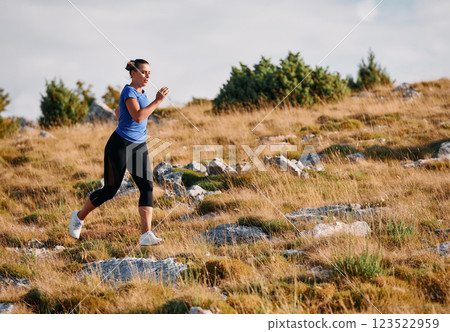 Empowered Runner Embracing Nature's Beauty on a Serene Morning Trail. 123522959