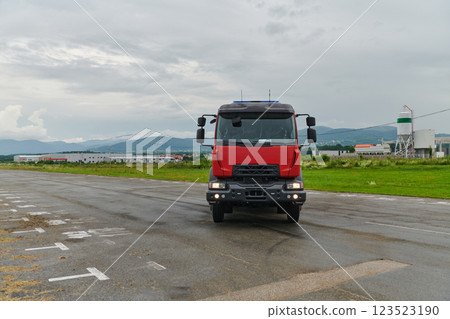 In this captivating scene, a state-of-the-art firetruck, equipped with advanced rescue technology, stands ready with its skilled firefighting team, prepared to intervene and respond rapidly to 123523190