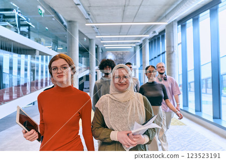 In the sleek corridors of a modern startup office, a diverse group of colleagues, led by their director, confidently stride forward, symbolizing collective success and the journey toward new business 123523191