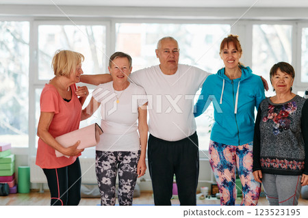 A group of seniors and one man happily pose with their yoga instructor after a successful training session. 123523195
