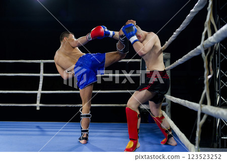 Kickboxing rivals unleash powerful leg strikes in a thrilling match. 123523252