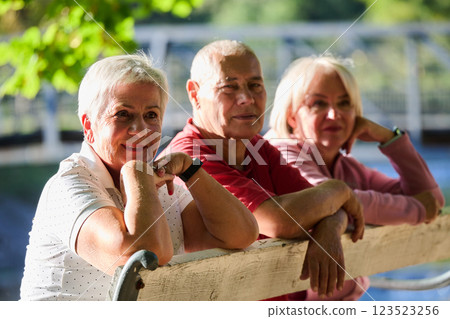 A group of elderly individuals, including a senior man and two older women, sits in a park on a sunny autumn day, embodying the concept of healthy aging through companionship, relaxation, and outdoor A group of elderly individuals, including a senior man and two older women, sits in a park on a sunny autumn day, embodying the concept of healthy aging through companionship, relaxation, and outdoor 123523256
