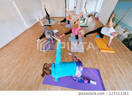 Wide Photo of Senior Women Embrace Wellness: Yoga and Stretching in a Sunlit Space Wide Photo of Senior Women Embrace Wellness: Yoga and Stretching in a Sunlit Space 123523261