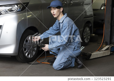 A man maintaining a car 123523291