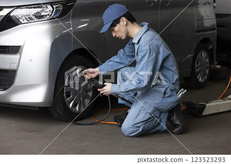 A man maintaining a car 123523293