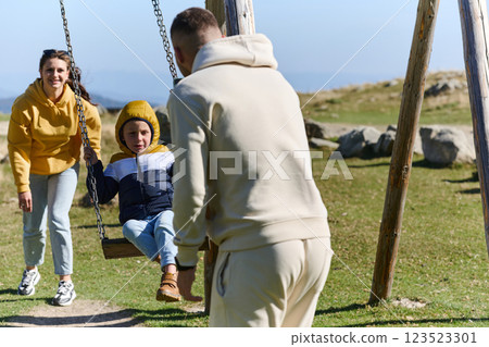 A modern family, along with their son, revels in the joy of a muddy day in nature, running and playing together, encapsulating the beauty of a healthy and active lifestyle 123523301