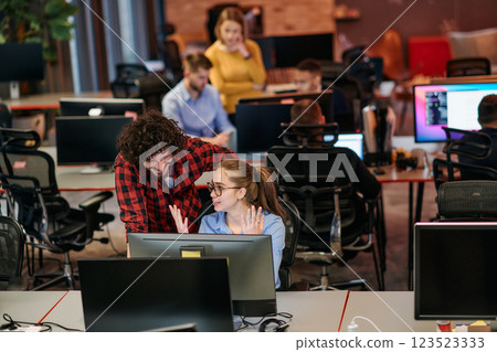 Business colleagues, a man and a woman, engage in discussing business strategies while attentively gazing at a computer monitor, epitomizing collaboration and innovation 123523333